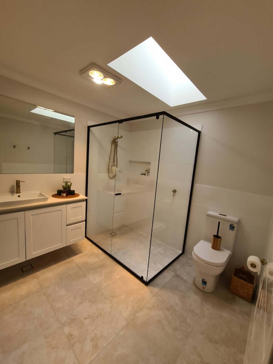 Semi-frameless shower screen with a matte black frame, installed in a renovated bathroom